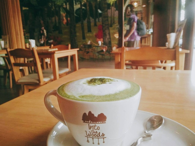 Latte cup on a table inside Into the Woods Cafe